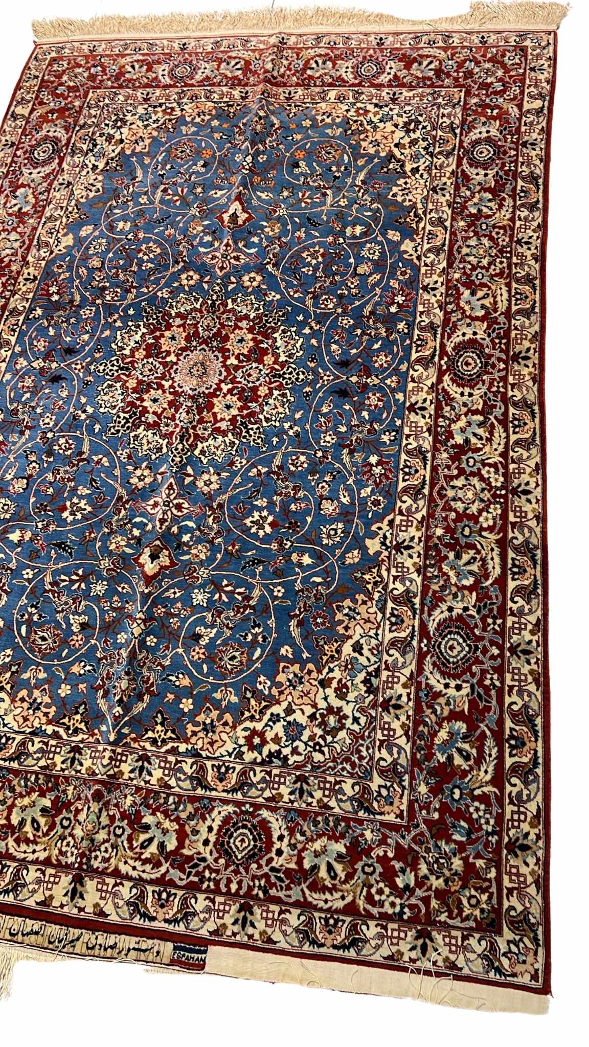 "Angled view of a luxury wool and silk Persian carpet, hand-knotted by Master Sadegh Seirafian, showcasing intricate craftsmanship and 50-year-old artistry."